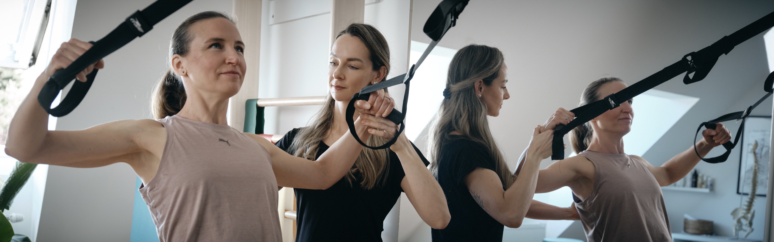Charlotte Schlenker korrigiert eine Übung am Schlingentrainer in ihrer Praxis in Purkersdorf